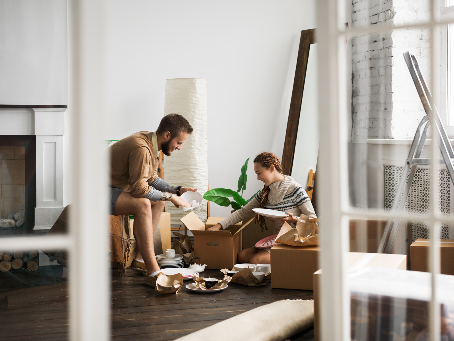 Couple taking items from packing boxes as they prepare their new home.